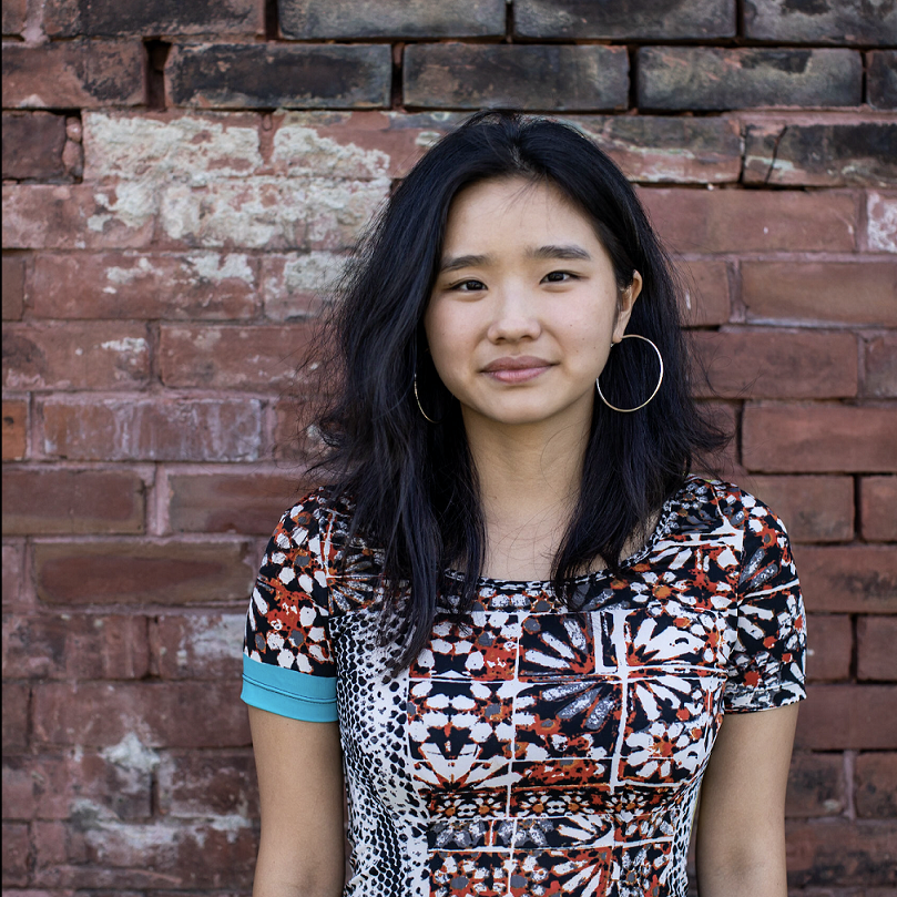 Sofia Jen Ouyang in front of a brick wall.