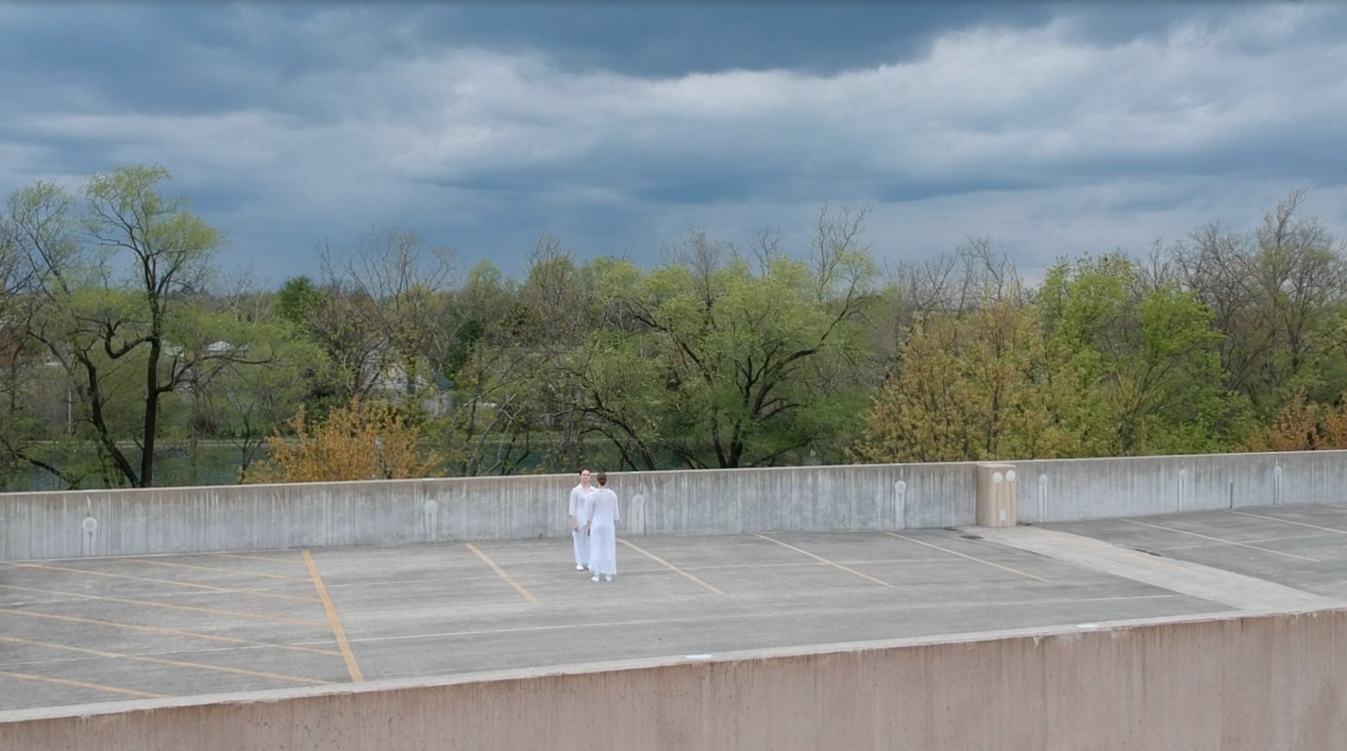 Picture of two people standing in a parking lot 