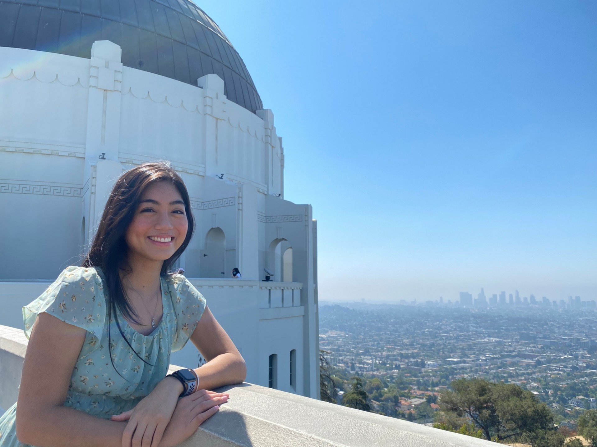 Mia Gonzalgo smiling at the camera in front of Griffith Observatory in Los Angeles.