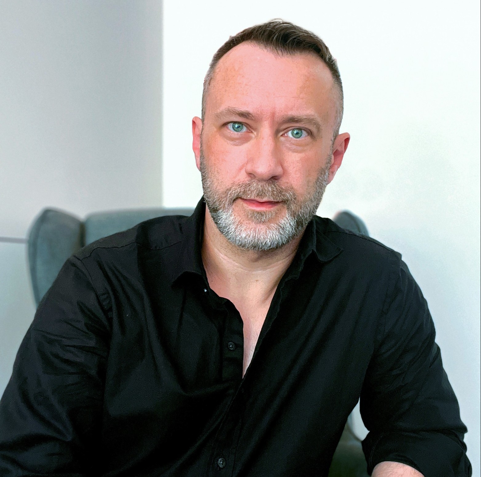 Mariusz Kozak in a black shirt in front of a white background