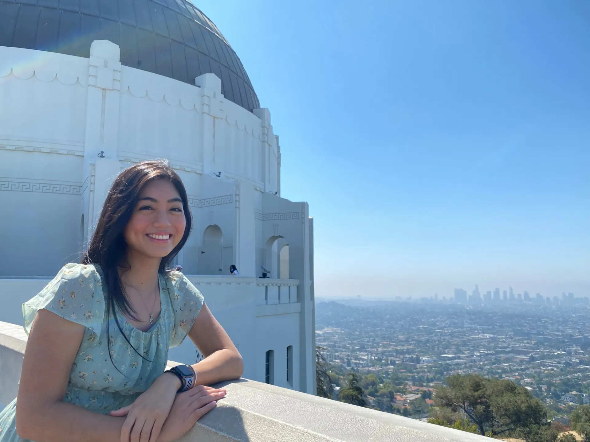 Mia Gonzalgo smiling at the camera in front of Griffith Observatory in Los Angeles.