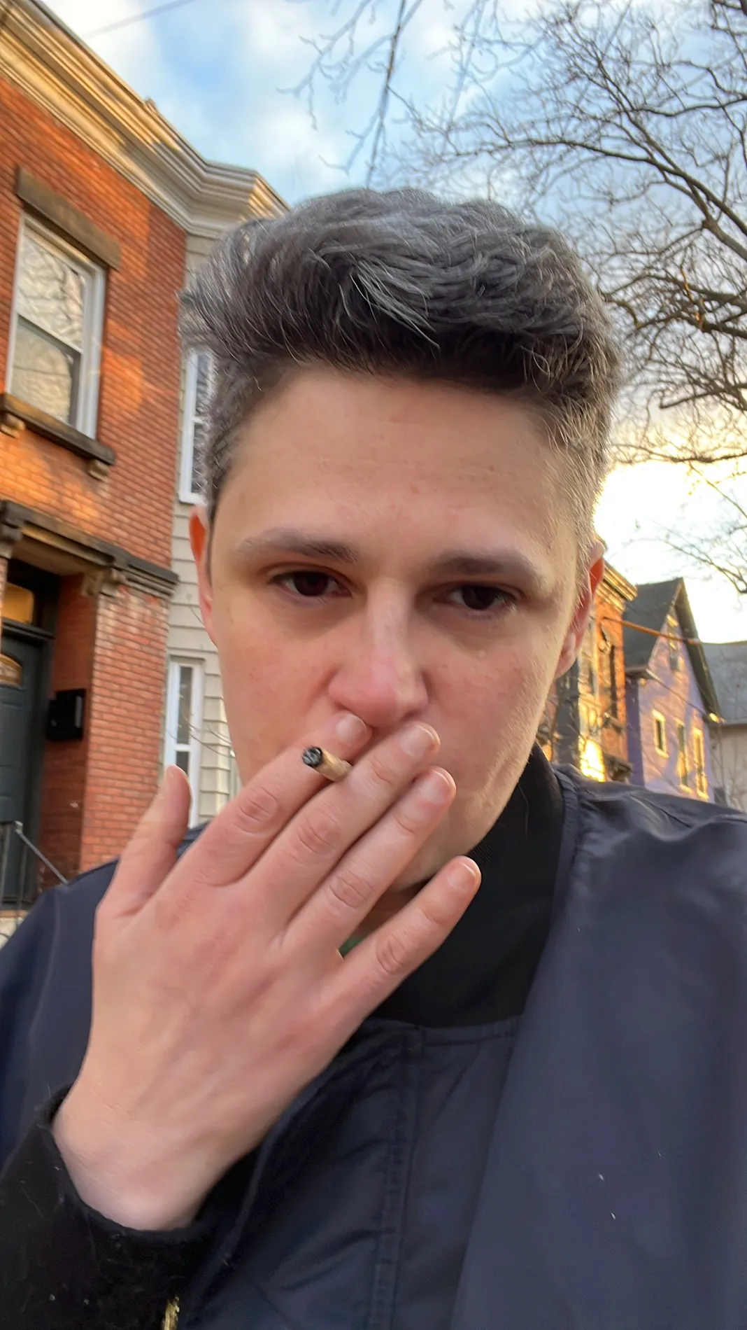AZ is looking at the camera and smoking a joint.