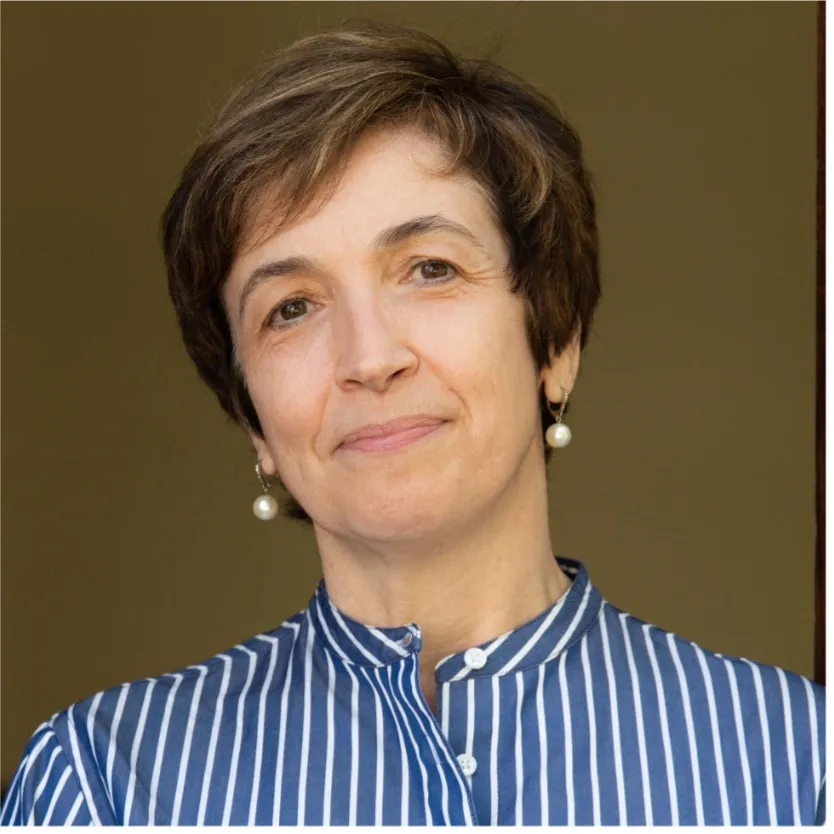 Professor Ciucci with pearl earrings and a blue and white striped shirt.