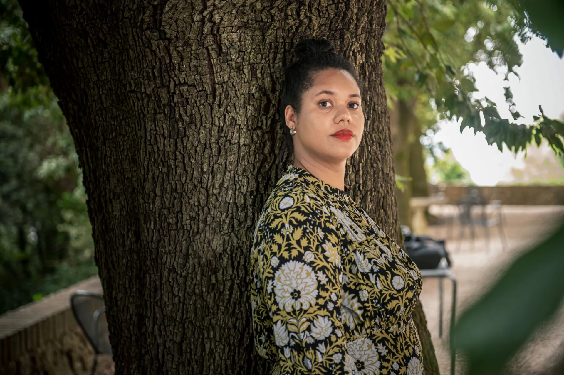 Hannah Kendall in a green and white patterned dress, in front of a tree.
