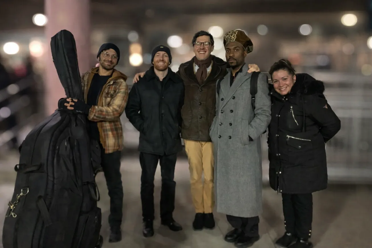 The musicians from Jazz at Lincoln Center stand smiling and stare at the camera.