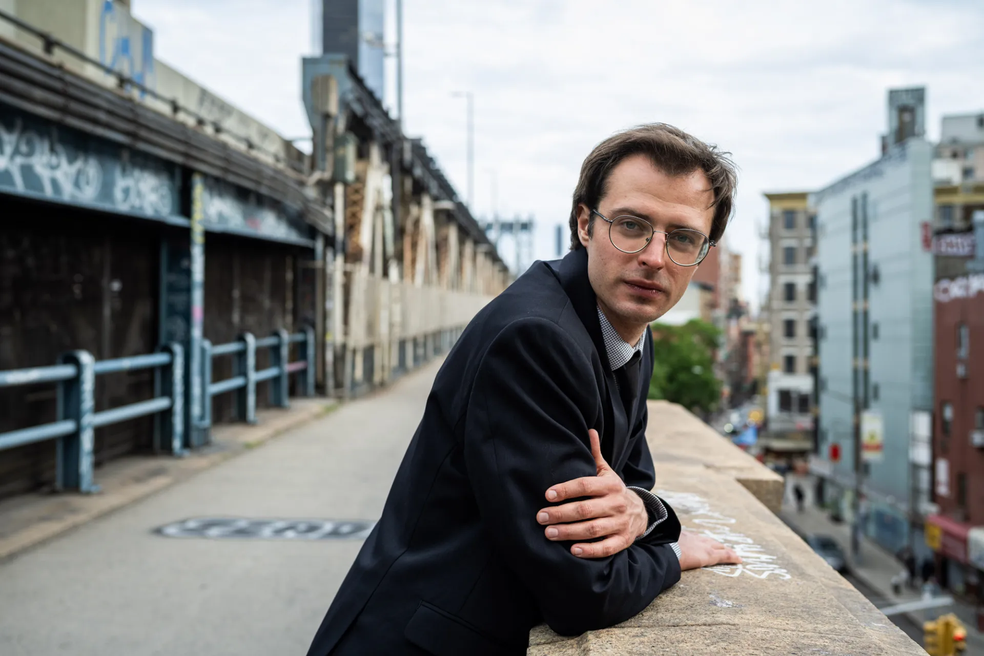 © Photo by Vytenis Jankūnas 

Kristupas leans against concrete infrastructure by a highway in a city. There is graffiti behind him. He looks directly at the camera, face stoic, with the barest hint of a smile.