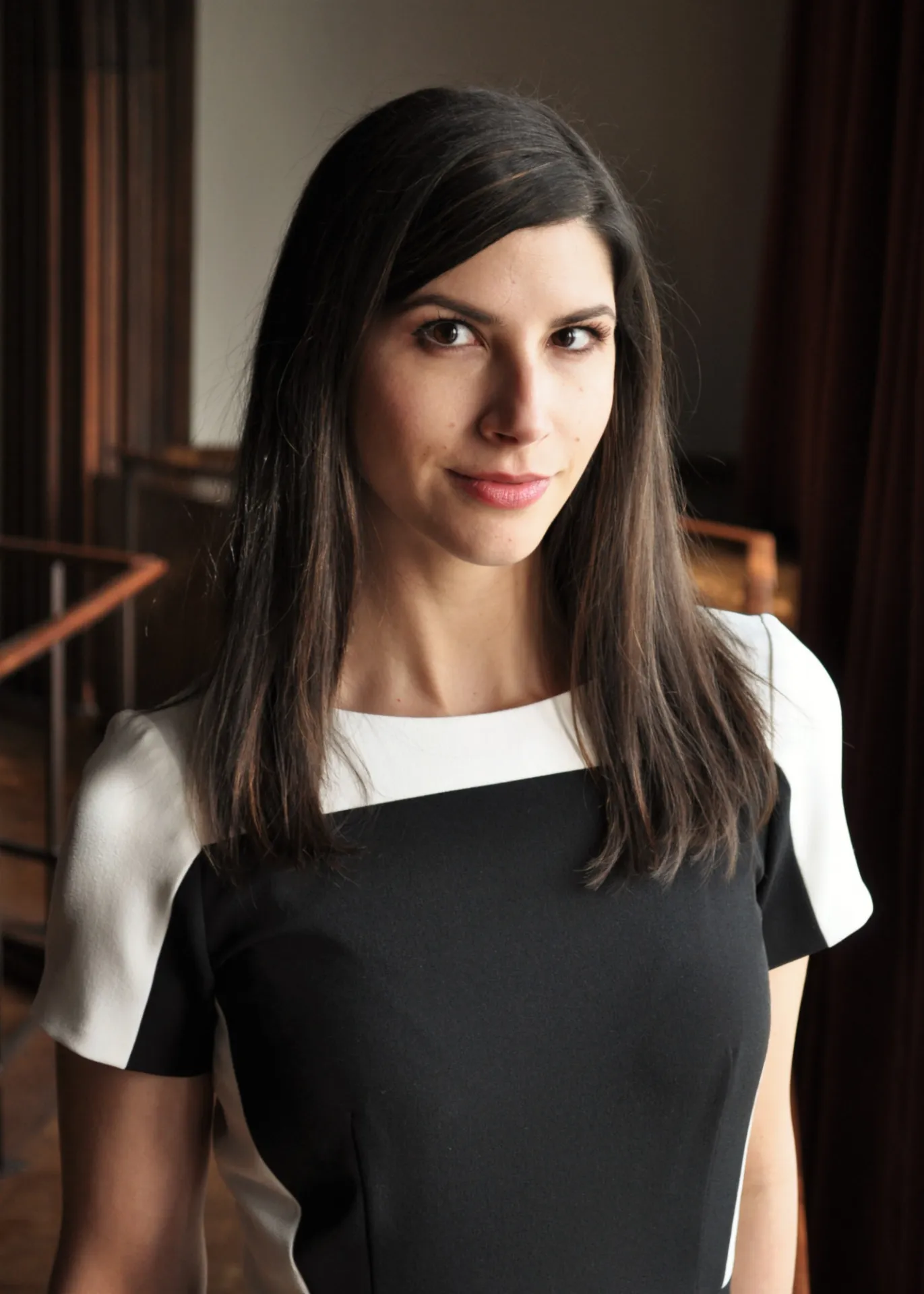 Jessica Peritz is facing the camera in a block white and black dress.