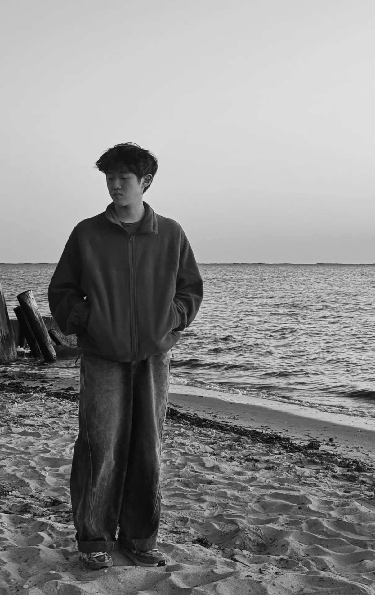 Won Jong on the beach, in black and white.